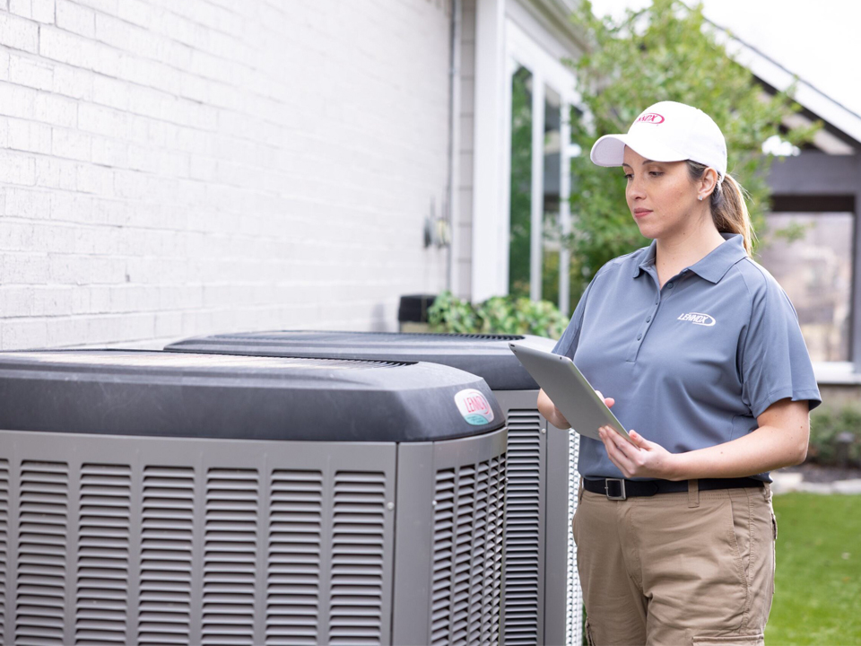 HVAC employee inspecting an air conditioner