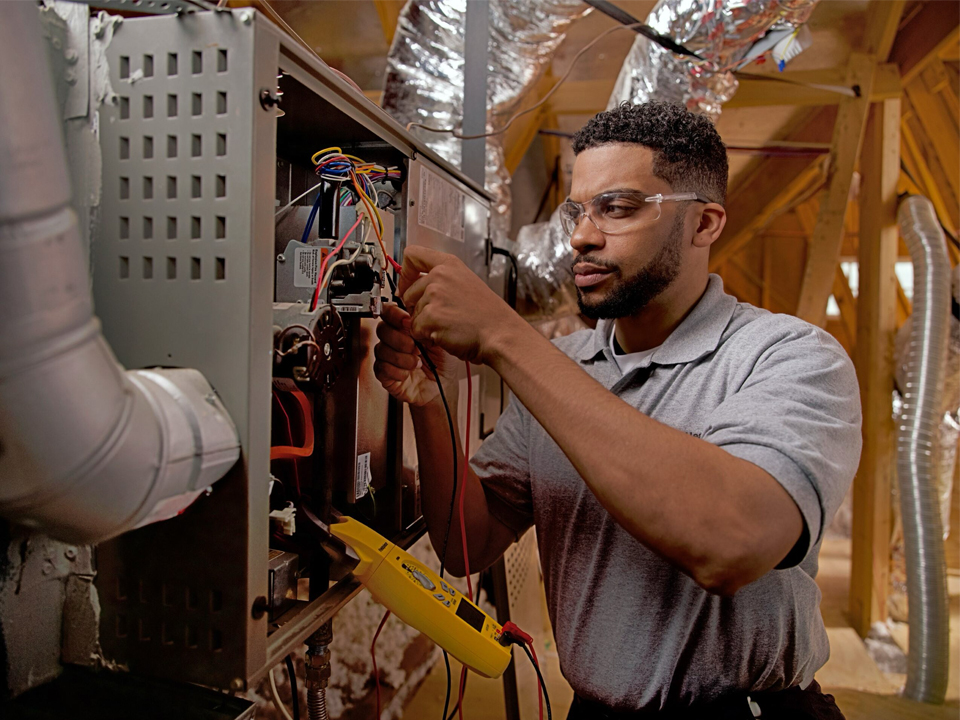 Employee fixing some wires on a furnace