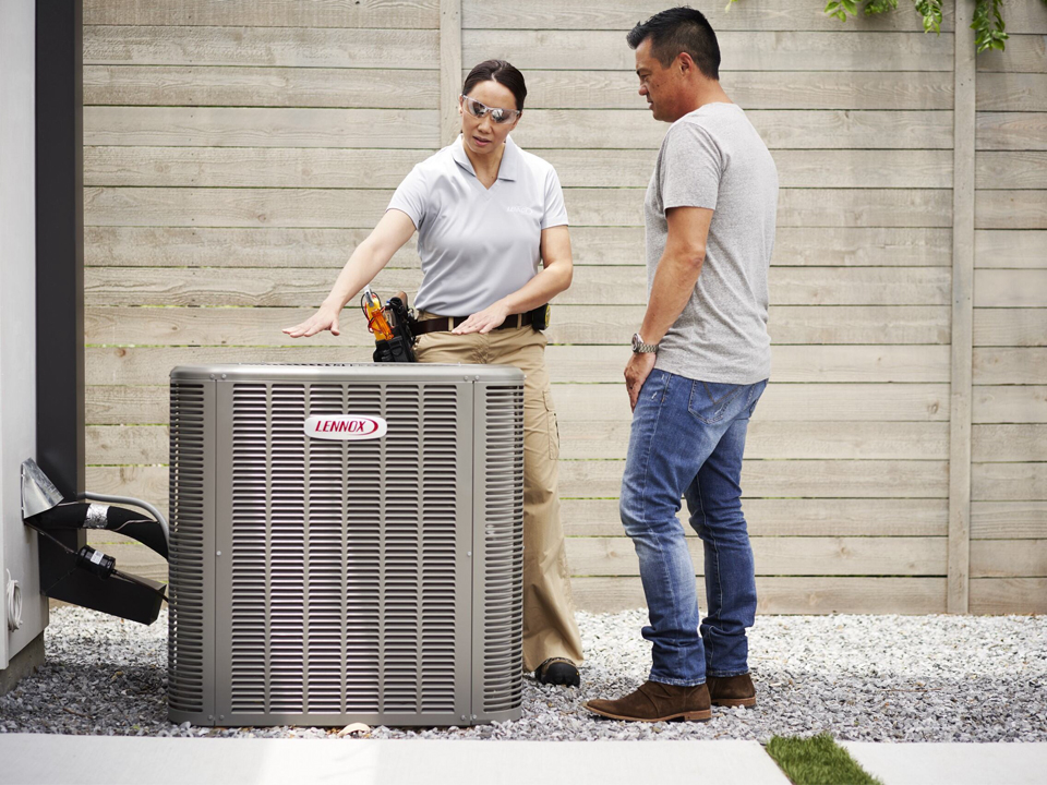 Smyth-NewConstruct-960×720 Employee showing homeowner their new air conditioning unit.