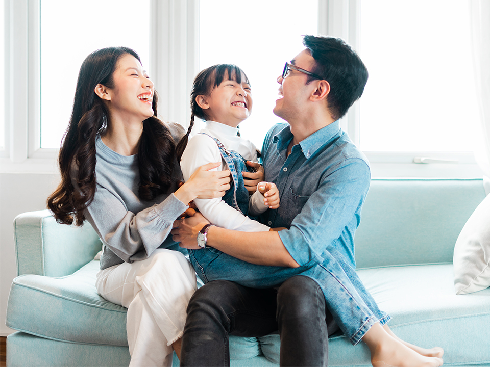 Smyth-NewConstruct-Family-960×720 Family sitting on their couch enjoying their Florida home.
